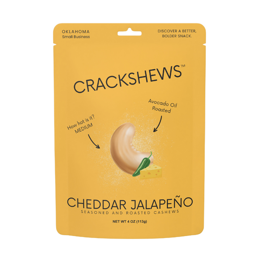 Packaging of Crackshews Cheddar Jalapeno cashews, 4oz, with a graphic of the cracked nut and text highlighting the flavor and product details.